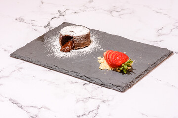 Chocolate Lava Cake Served With Strawberries On A Marble Countertop