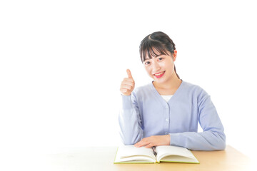 勉強をしながら指を指す若い女子学生