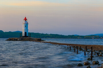 Tokarevsky lighthouse in Vladivostok. Old white lighthouse on the background of the sea and the...