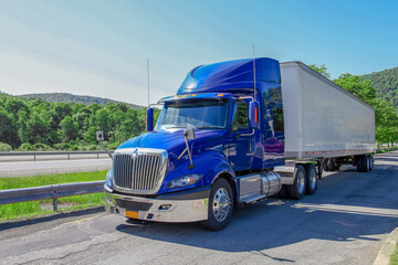 The blue truck and white container in transport industry is stop and rest on high way © pumppump