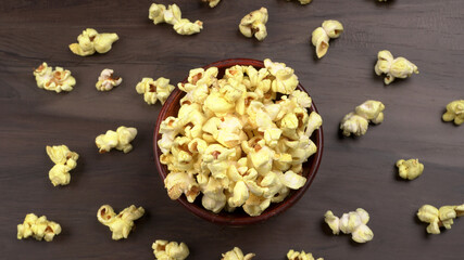 Heap of delicious popcorn. Scattered popcorn texture background. Selective focus. Salt popcorn on the wooden table.