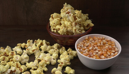 Heap of delicious popcorn. Scattered popcorn texture background. Selective focus. Salt popcorn on the wooden table.