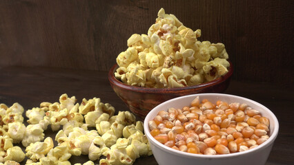 Heap of delicious popcorn. Scattered popcorn texture background. Selective focus. Salt popcorn on the wooden table.