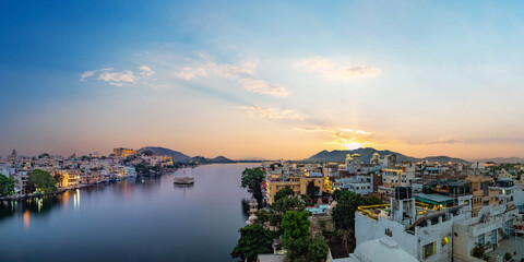 Udaipur city at lake Pichola in the evening, Rajasthan, India. View of City palace reflected on the...