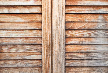 Wooden shutters close-up. Doors with transverse thin boards and openings between them. Wooden doors.