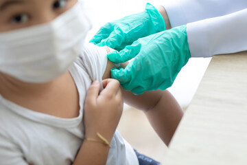 Fototapeta premium Asian little girl getting dengue vaccine. Pediatrician. pediatric checkup in hospital children medical care Doctor pediatric holds an injection vaccination the child.