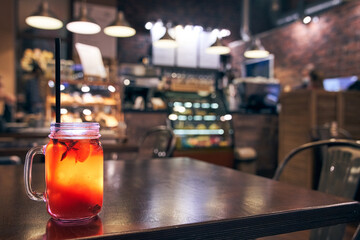 Christmas drink red non-alcoholic mulled wine with a straw on the background of the cafe interior,...