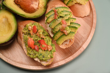 Close up view avocado sandwiches on wooden plate.