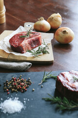 Raw steak on the table
Cooking. Raw piece of steak on the table with piece of rosemary
