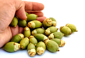 Artistic composition using green betel nut and hands on a white background.