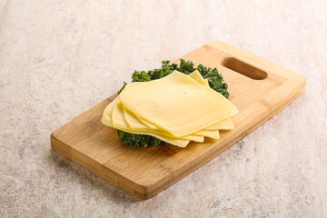 Sliced Gouda cheese over board