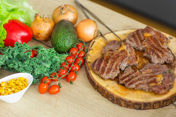 well done veal meat steak and vegetables on the kitchen table