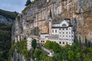 Aerial view of the church on the sheer cliff. Italian church at high altitude in the Alps. The unique Sanctuary Madonna della Corona church in the rock. The sanctuary is high in the mountains of Italy