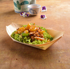 asian hakka traditional cuisine snack menu stir fried abacus ball with minced meat and mushroom in small paper bowl on wood table (suan pan zi)