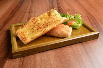 oven baked garlic butter French toast bread on lettuce and bamboo plate wood table pastry halal menu