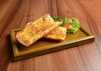 oven baked garlic butter French toast bread on lettuce and bamboo plate wood table pastry halal menu