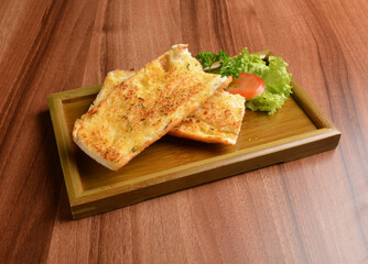 oven baked garlic butter French toast bread on lettuce and bamboo plate wood table pastry halal menu