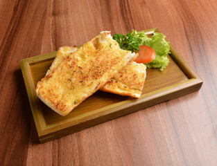 oven baked garlic butter French toast bread on lettuce and bamboo plate wood table pastry halal menu