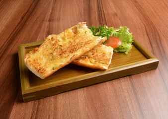 oven baked garlic butter French toast bread on lettuce and bamboo plate wood table pastry halal menu