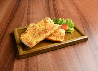 oven baked garlic butter French toast bread on lettuce and bamboo plate wood table pastry halal menu