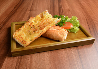 oven baked garlic butter French toast bread on lettuce and bamboo plate wood table pastry halal menu