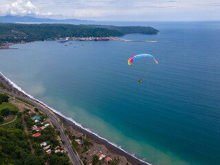 Beautiful aerial view of the extreme sport of paragliding on the Beach and mountains of Costa Rica 