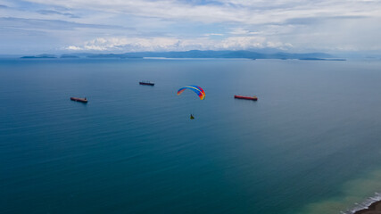 Fototapeta na wymiar Beautiful aerial view of the extreme sport of paragliding on the Beach and mountains of Costa Rica 