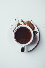 Taza de café con galletas y granos molidos en fondo blanco