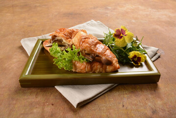 asian stir fried assorted mushroom and vegetables in freshly baked croissant on bamboo plate and...
