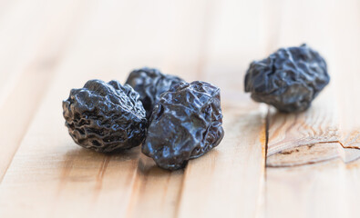 Closeup shot of dried plums on a wooden surface