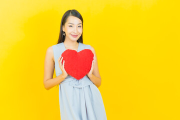 Portrait beautiful young asian woman smile with heart pillow shape