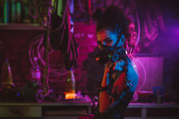 Fototapeta na wymiar Cyberpunk cosplay. A girl in a gas mask in a post-apocalyptic style with neon lighting