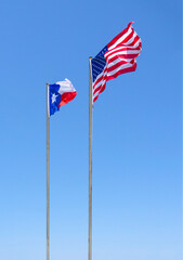 Flags of United States and state Texas (Texas flag) against the blue sky in Greece