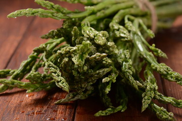 Asparagus. Fresh green asparagus on wooden table background. Bunch of fresh ripe green asparagus organic vegetables ready to cook or grill