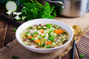 Chicken fillet vegetable soup in  bowl on wooden rustic table.
