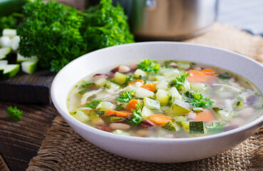 Chicken fillet vegetable soup in  bowl on wooden rustic table.
