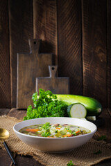 Chicken fillet vegetable soup in  bowl on wooden rustic table.