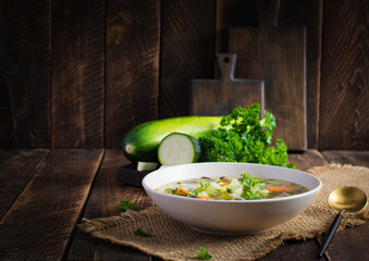 Chicken fillet vegetable soup in  bowl on wooden rustic table.