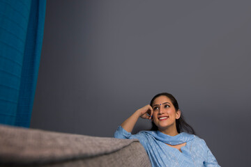 A cheerful woman sitting in her room.