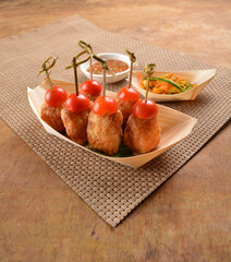 deep fried shrimp paste roll (wu Xiang) with achar and spicy sauce in bento box on wood table asian snack halal menu