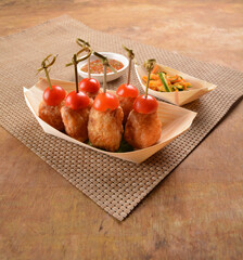 deep fried shrimp paste roll (wu Xiang) with achar and spicy sauce in bento box on wood table asian...
