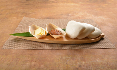 steamed bun (man tou) with kaya and butter jam on pandan leaf board wood table asian bread halal menu