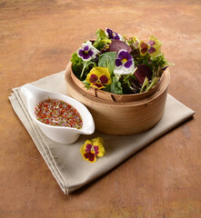 beautiful flower vegetables salad in bamboo basket with homemade salad dressing sauce on wood table asian vegan halal menu