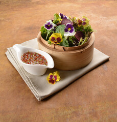 beautiful flower vegetables salad in bamboo basket with homemade salad dressing sauce on wood table asian vegan halal menu