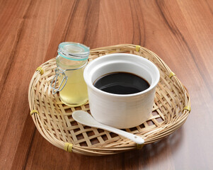chilled black herbal jelly pudding (Gui ling gao) with fresh honey syrup dessert on wood table...