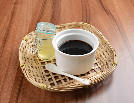 chilled black herbal jelly pudding (Gui ling gao) with fresh honey syrup dessert on wood table dessert halal menu