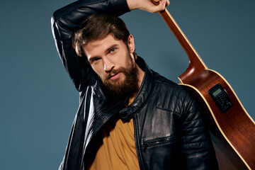 man in black leather jacket holding guitar music celebrity lifestyle