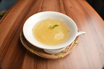 chilled sweet lemongrass jelly pudding with gui hua flower dessert in bowl on wood table asian dessert halal menu