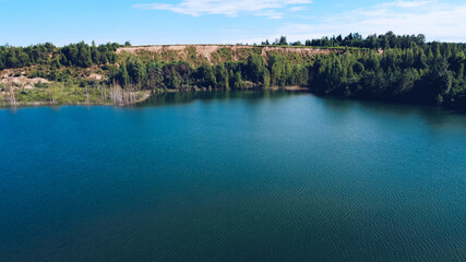 Picturesque blue lake summer landscape for outdoors vacation. Hill with lush greenery behind the middle of lake. Volokolamsk district of Moscow region. Sychevo beach, Russia