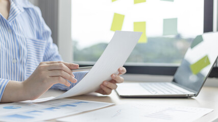 Asian business women are analyzing graphs, financial statistics and calculating corporate returns in private offices, Market research reports and income statistics, Financial and Accounting concept.